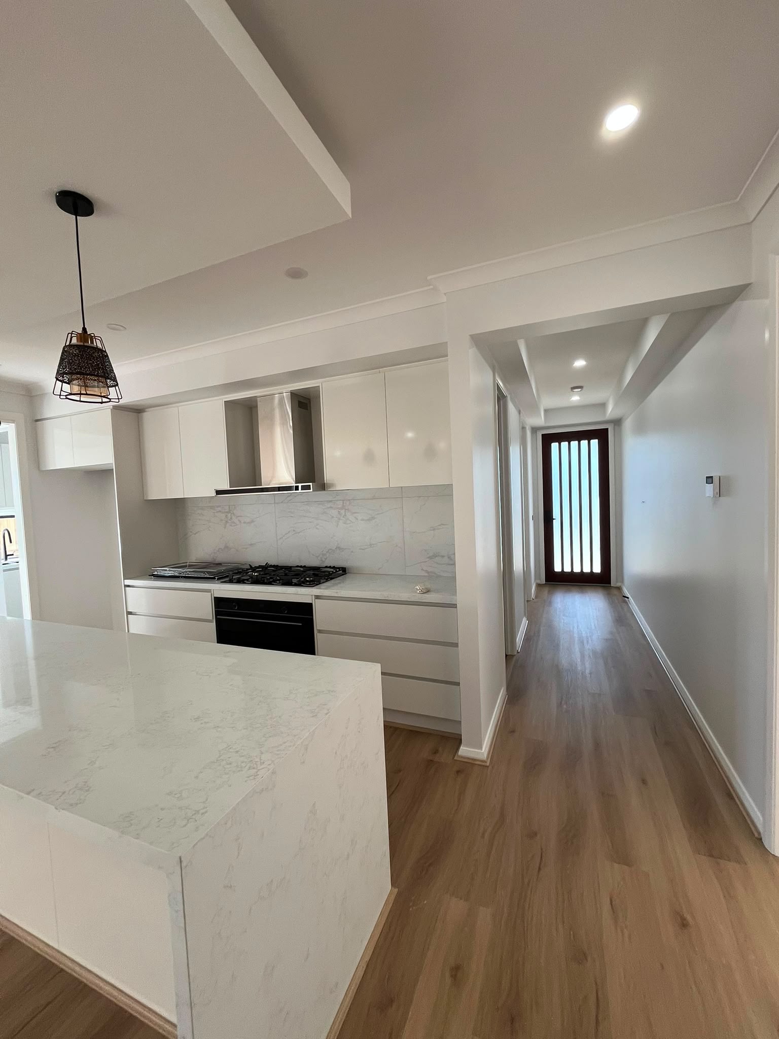Freshly painted white kitchen and hallway in a Melbourne home