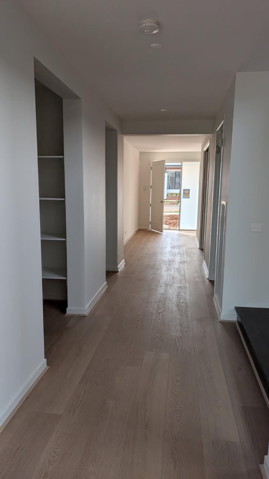 Entry hallway with painted built-in shelving and crisp white skirting